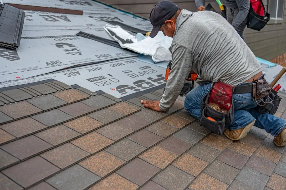 Roofing installer fastening shingles over new underlayment in Vallejo, CA